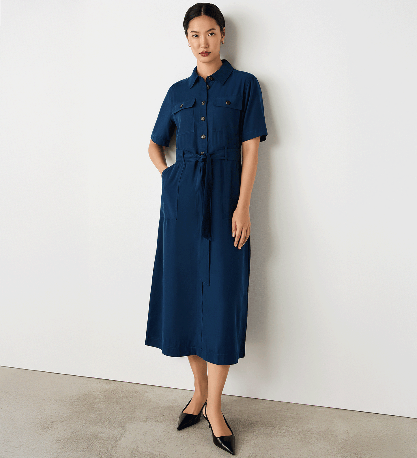 Full body view of a model wearing the Cassidy Navy Shirt Dress, one hand in the cargo pockets.