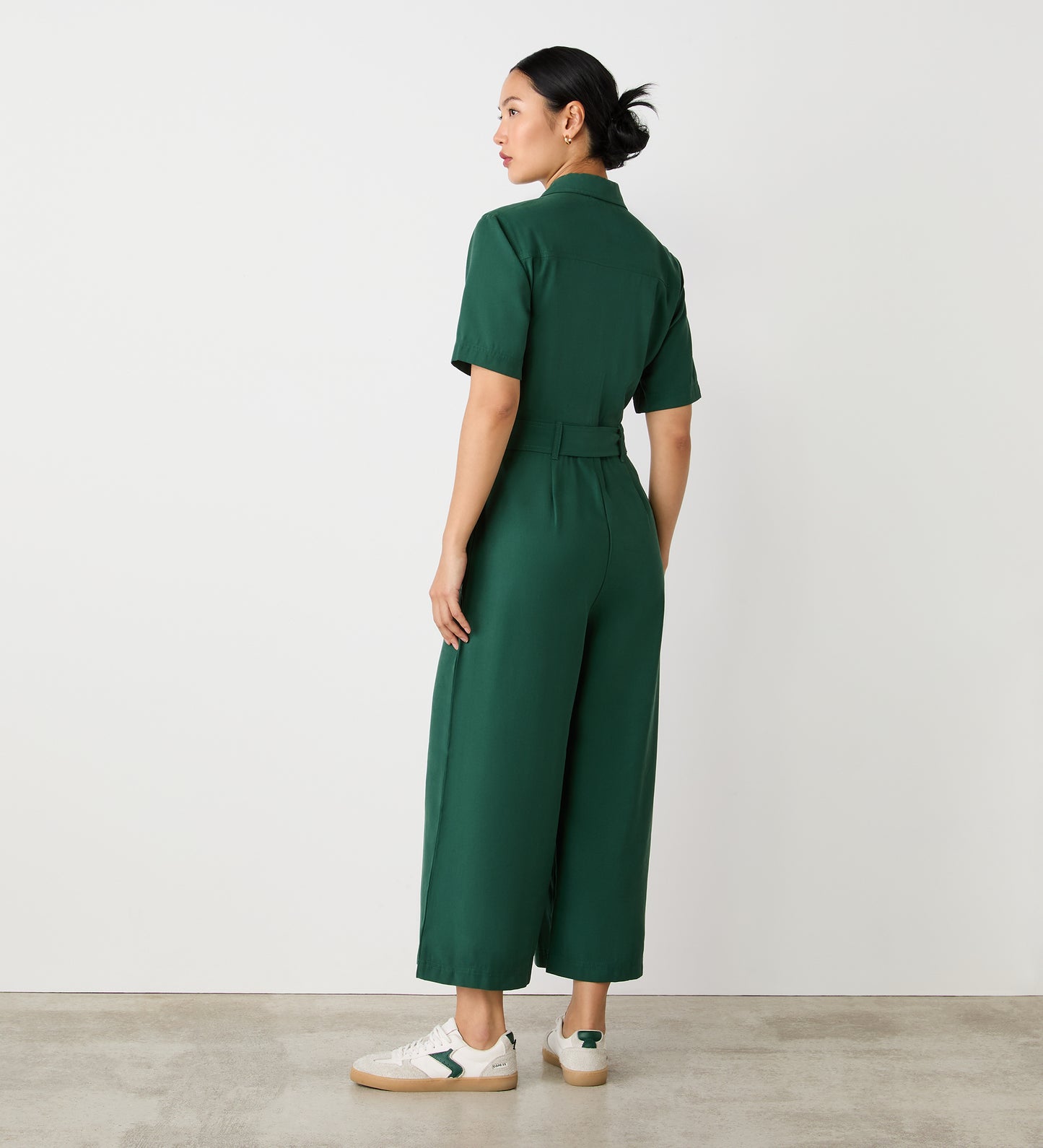 Full body back view of a model wearing the Marie Dark Green Utility Jumpsuit facing away from the camera.