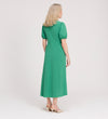 A woman with blonde hair wears the Robyn Green Button Through Midi Dress with puff sleeves and beige heels, standing against a plain white background and looking to the side.