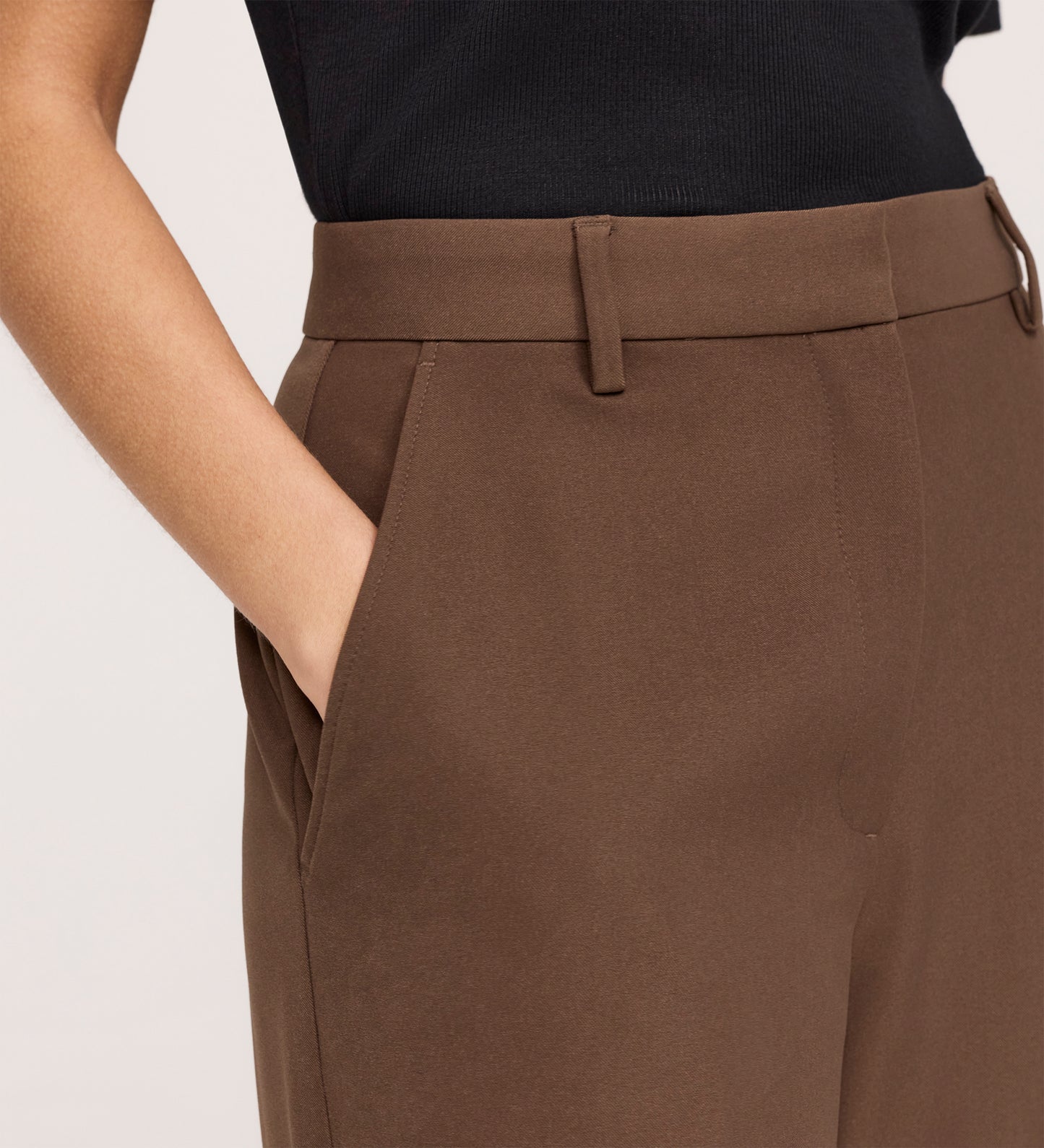 Close-up of a woman wearing the Addie Mushroom Gaberdine Twill Wide Leg Trousers, featuring a high-waisted fit with belt loops and side pockets, paired with a black top.
