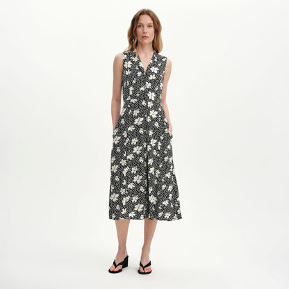Woman wearing a Beatrice Black Ditsy Sleeveless Midi Shirt Dress white background