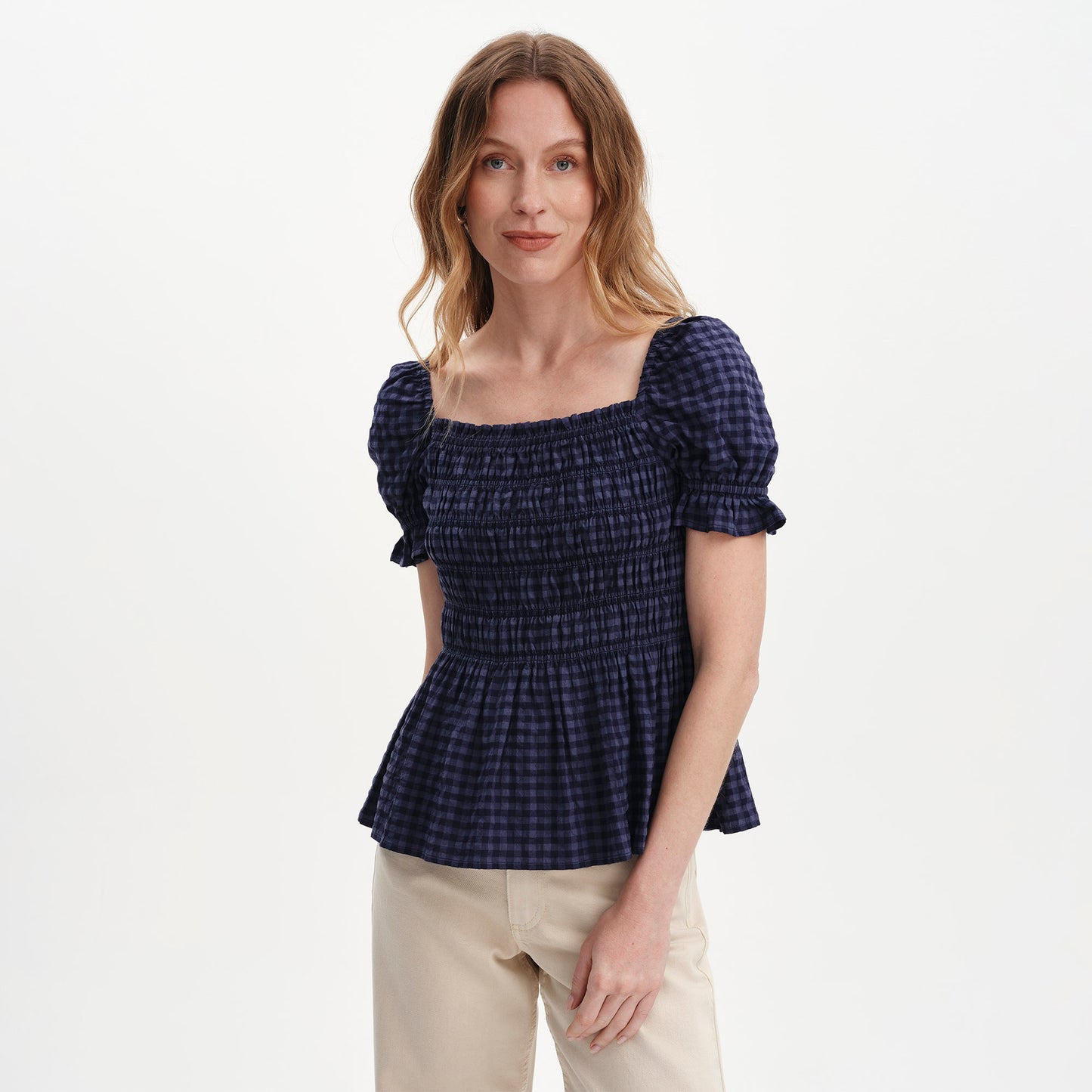 Woman wearing Cynthia Navy Gingham Seersucker Shirred Puff Sleeve Top on a white background