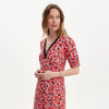 Woman wearing Elish Red Ditsy Lace Trim Puff Sleeve Midi Dress on a white background