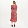 Woman wearing Elish Red Ditsy Lace Trim Puff Sleeve Midi Dress on a white background