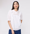 Woman wearing Jolin White Lace Cotton Puff Sleeve Top with lace details on a plain background