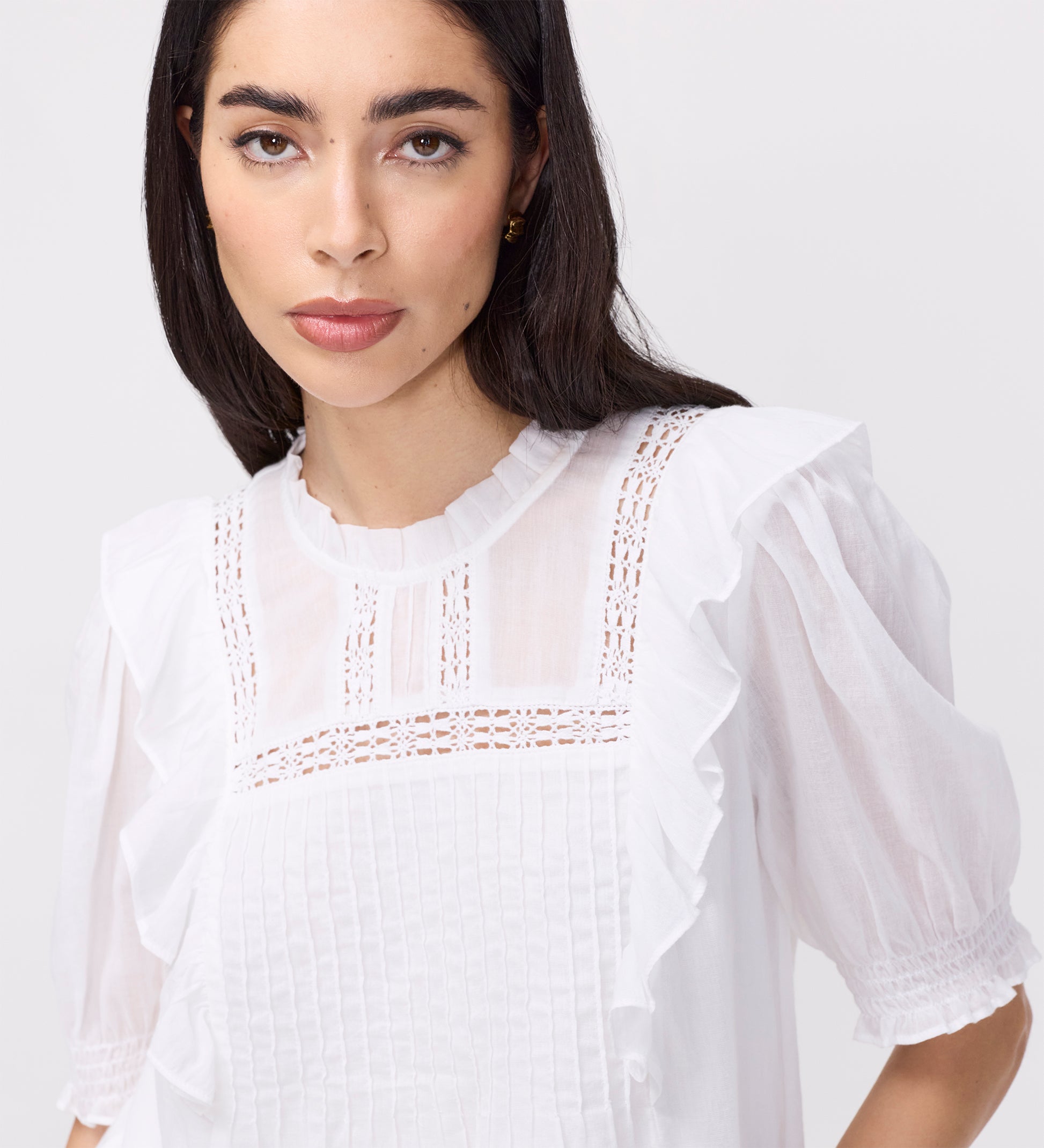 Woman wearing Jolin White Lace Cotton Puff Sleeve Top details on a plain background