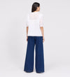Woman wearing Jolin White Lace Cotton Puff Sleeve Top and blue jeans on a white background