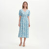Woman wearing Margot Blue Ditsy Puff Sleeve Button Through Midi Dress on a white background