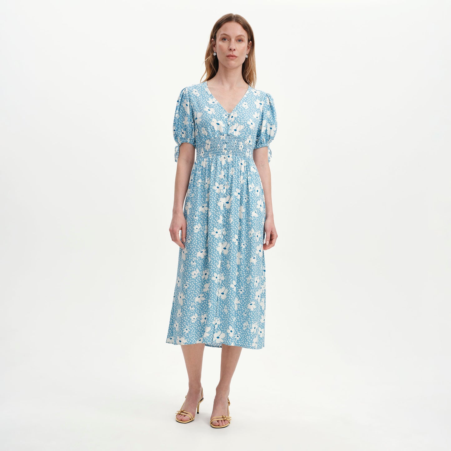 Woman wearing Margot Blue Ditsy Puff Sleeve Button Through Midi Dress on a white background