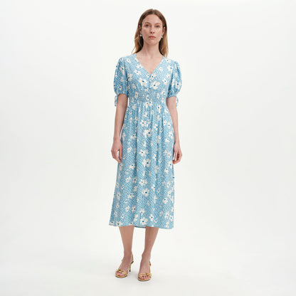 Woman wearing Margot Blue Ditsy Puff Sleeve Button Through Midi Dress on a white background