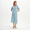 Woman wearing Margot Blue Ditsy Puff Sleeve Button Through Midi Dress on a white background