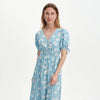 Woman wearing Margot Blue Ditsy Puff Sleeve Button Through Midi Dress on a white background