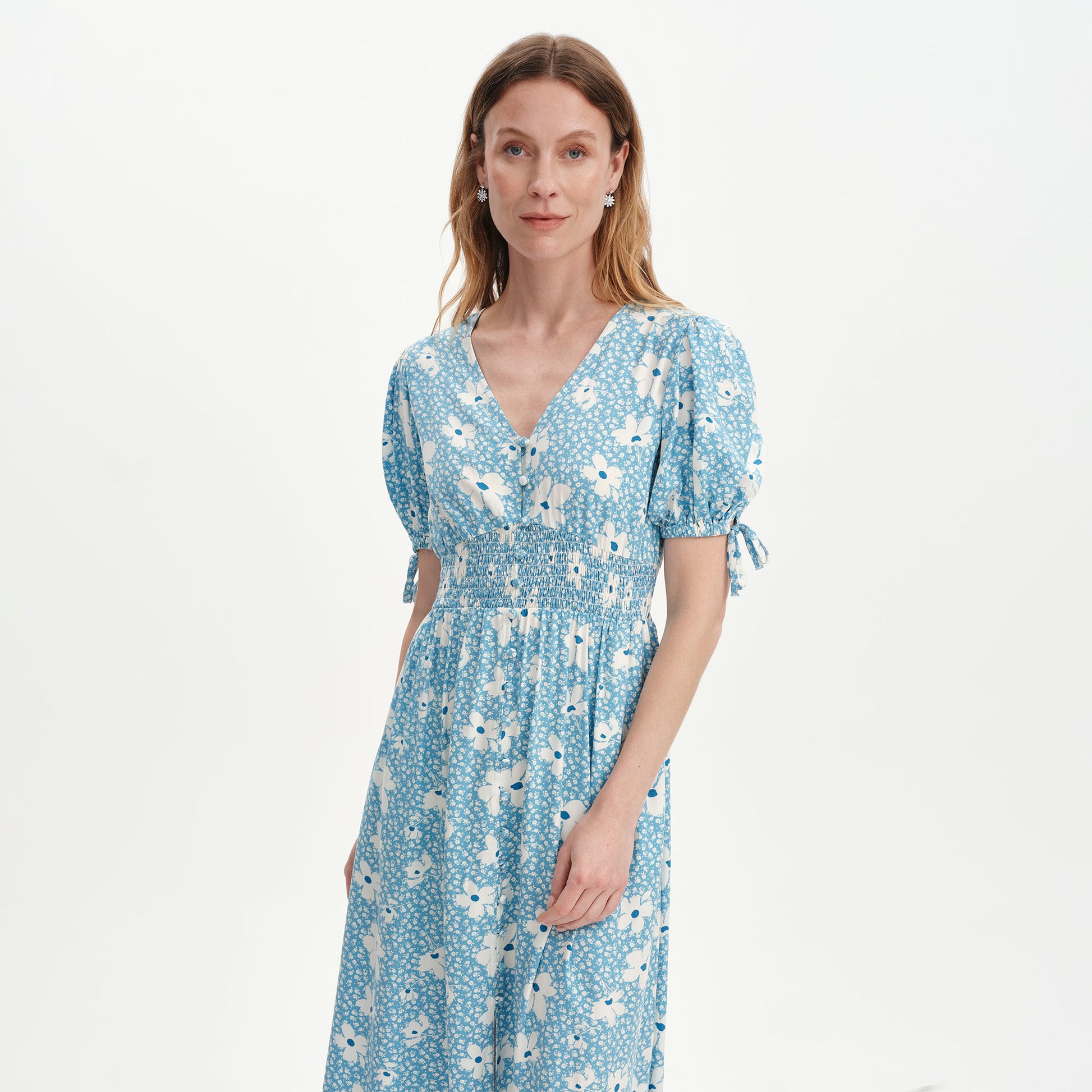 Woman wearing Margot Blue Ditsy Puff Sleeve Button Through Midi Dress on a white background