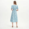 Woman wearing Margot Blue Ditsy Puff Sleeve Button Through Midi Dress on a white background