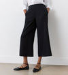 Wearing Simone Black Cropped Wide Leg Trousers with an elasticated waistband, a white long-sleeve shirt, and black pointed-toe flats, this look is perfect for a stylish wardrobe.