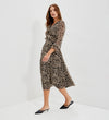 A woman modeling Veronica Natural Animal Ruffle Empire Waist Midi Dress, paired with black pointed-toe mule heels, set against a clean white studio background.
