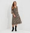 A woman modeling Veronica Natural Animal Ruffle Empire Waist Midi Dress, paired with black ankle boots, standing in a white studio corner.