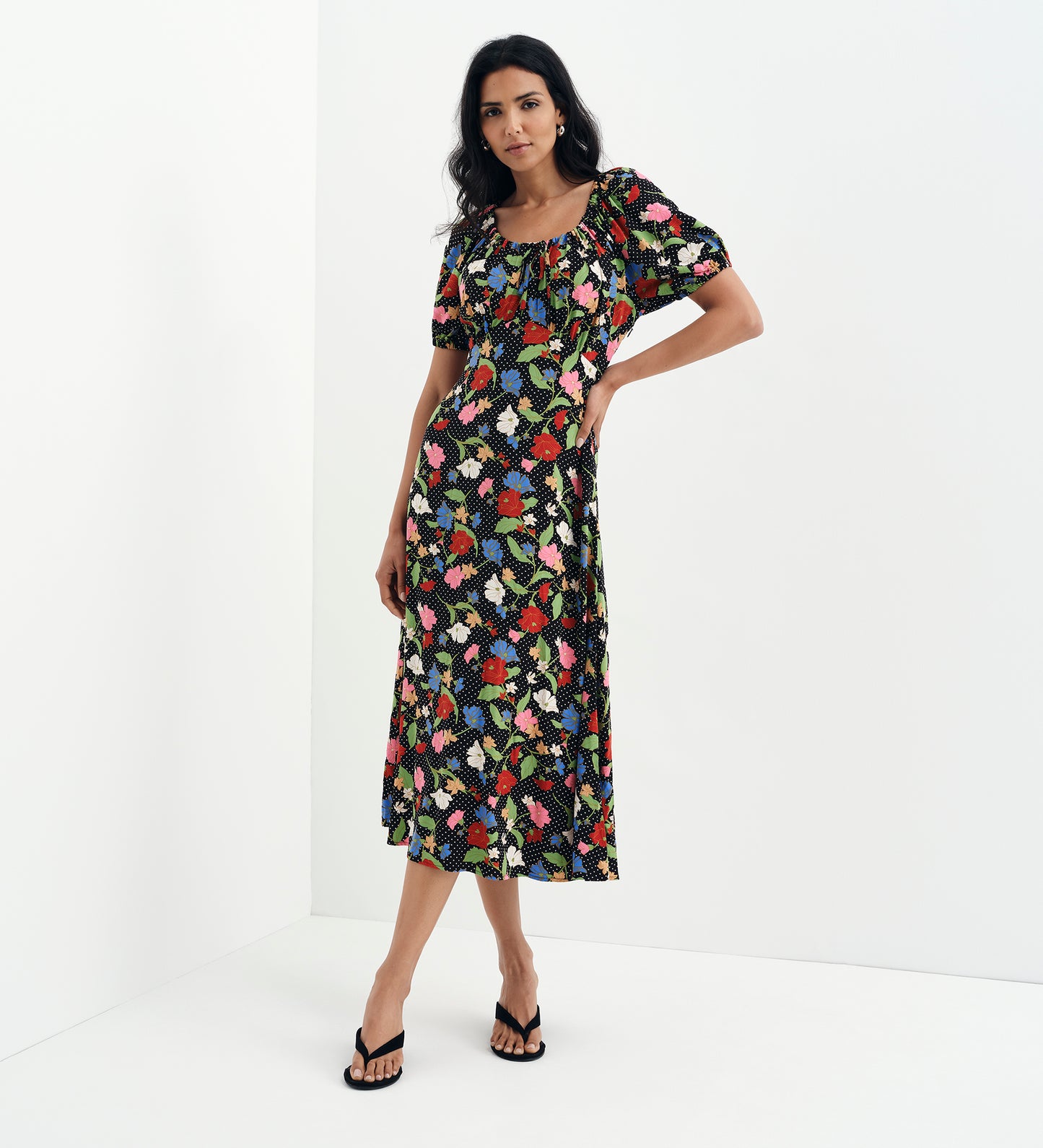 Woman wearing Jada Black Floral Puff Sleeve Empire Waist Midi Dress on a white background