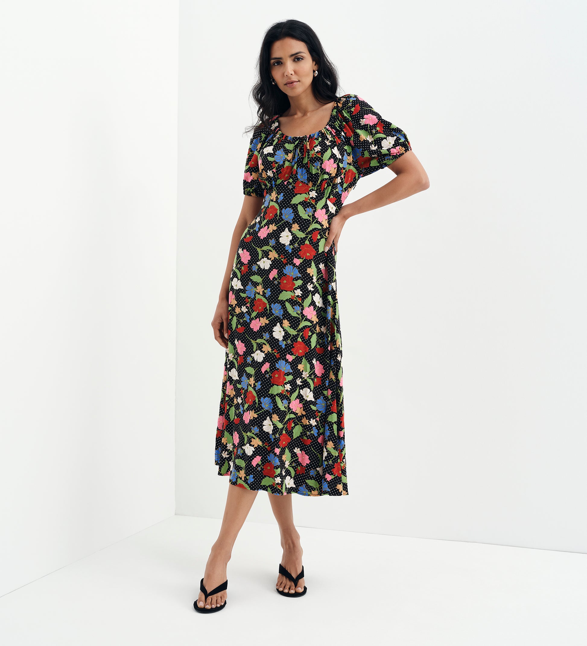 Woman wearing Jada Black Floral Puff Sleeve Empire Waist Midi Dress on a white background