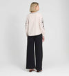 Woman wearing a Karlee Neutral Stripe Embroidered Cotton Tie Front Blouse and black pants on a white background