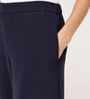 A person wearing Nat Navy Gaberdine Twill Wide Leg Trousers with their right hand in the pocket, shown waist down against a light background.