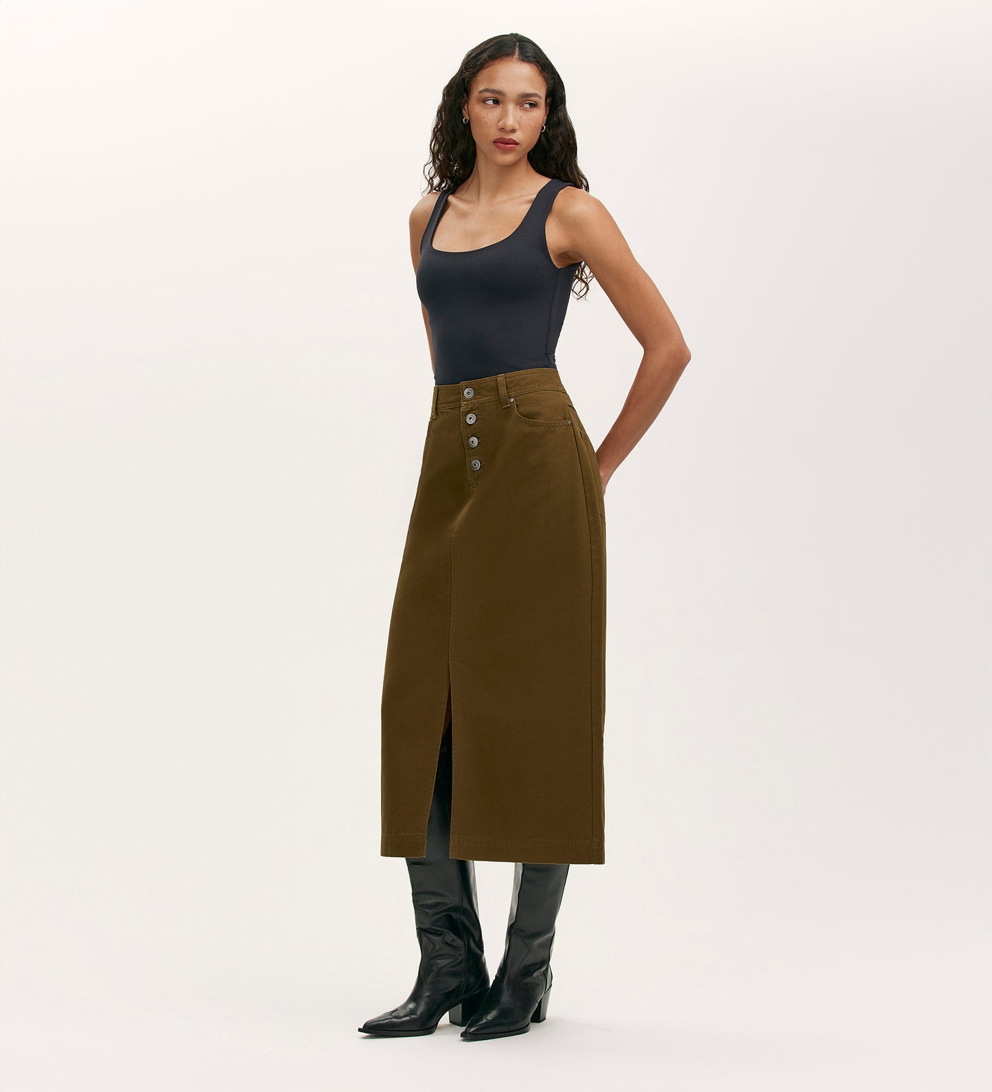 A woman wears the Beth Khaki Canvas Midi Skirt, featuring a high waistband.