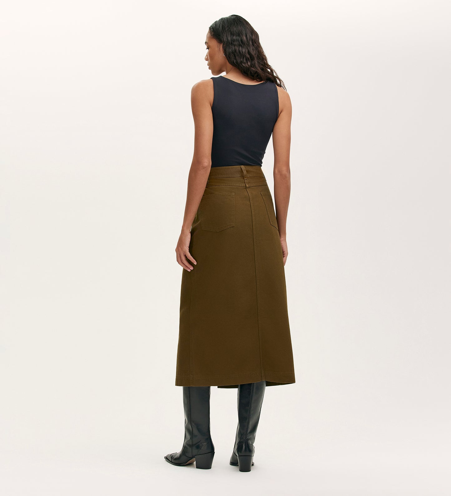 A woman in the Beth Khaki Canvas Midi Skirt with a high waistband.