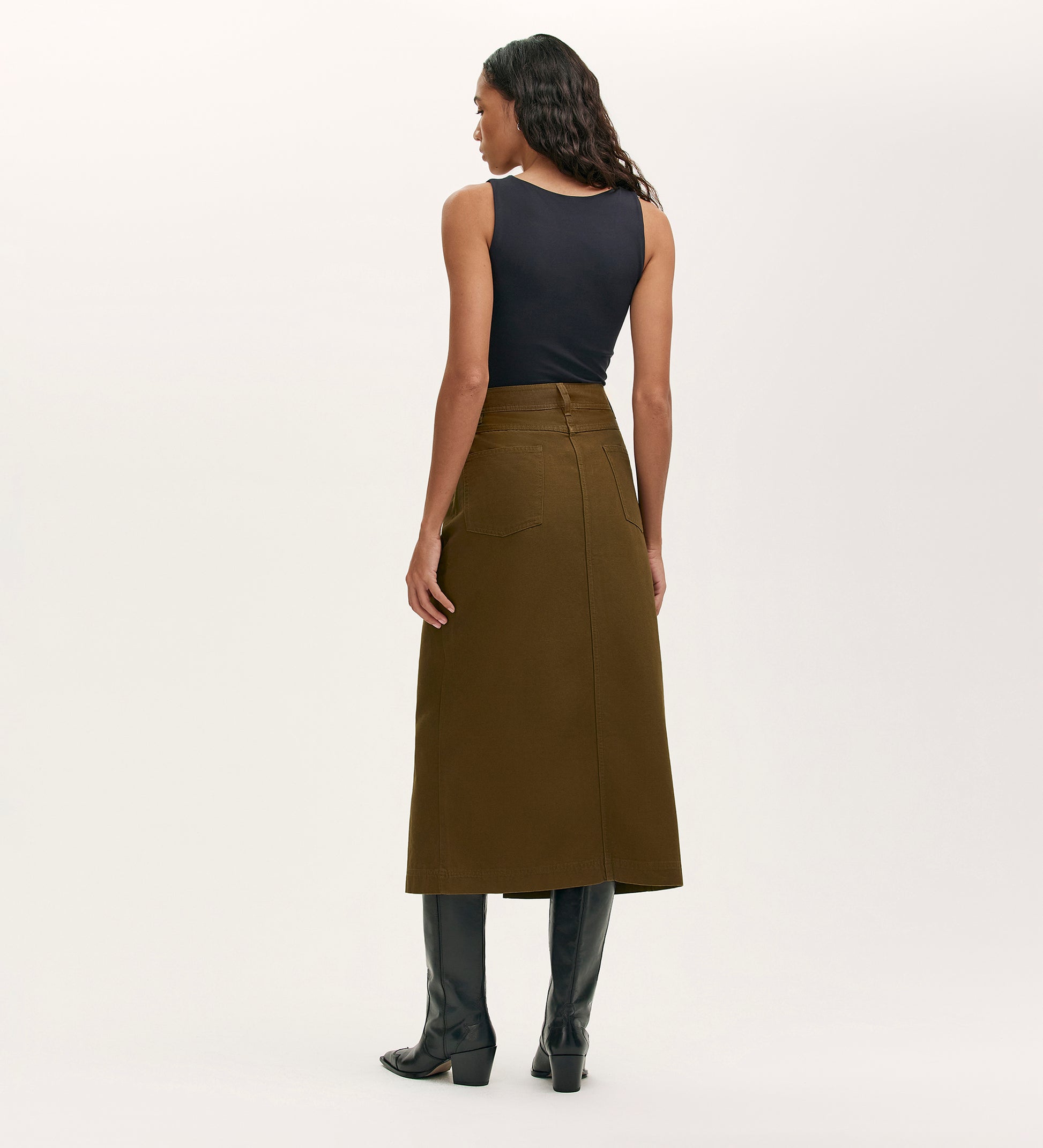 A woman in the Beth Khaki Canvas Midi Skirt with a high waistband.