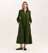 A woman with loose hair wears the Callie Khaki Corduroy Midi Dress, featuring a zip-front closure, side pockets, and a tiered skirt, styled with black flat shoes against a plain background.