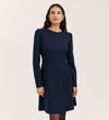 A woman with long dark hair models the Eva Navy Ponte Jersey Short Dress, a knee-length design with princess seams and long sleeves, set against a plain light background.