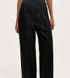 A person models the Olive Black Canvas Wide Leg Trousers—high-waisted with front pockets—in an elevated casual style, shown from waist to ankles against a plain light background.