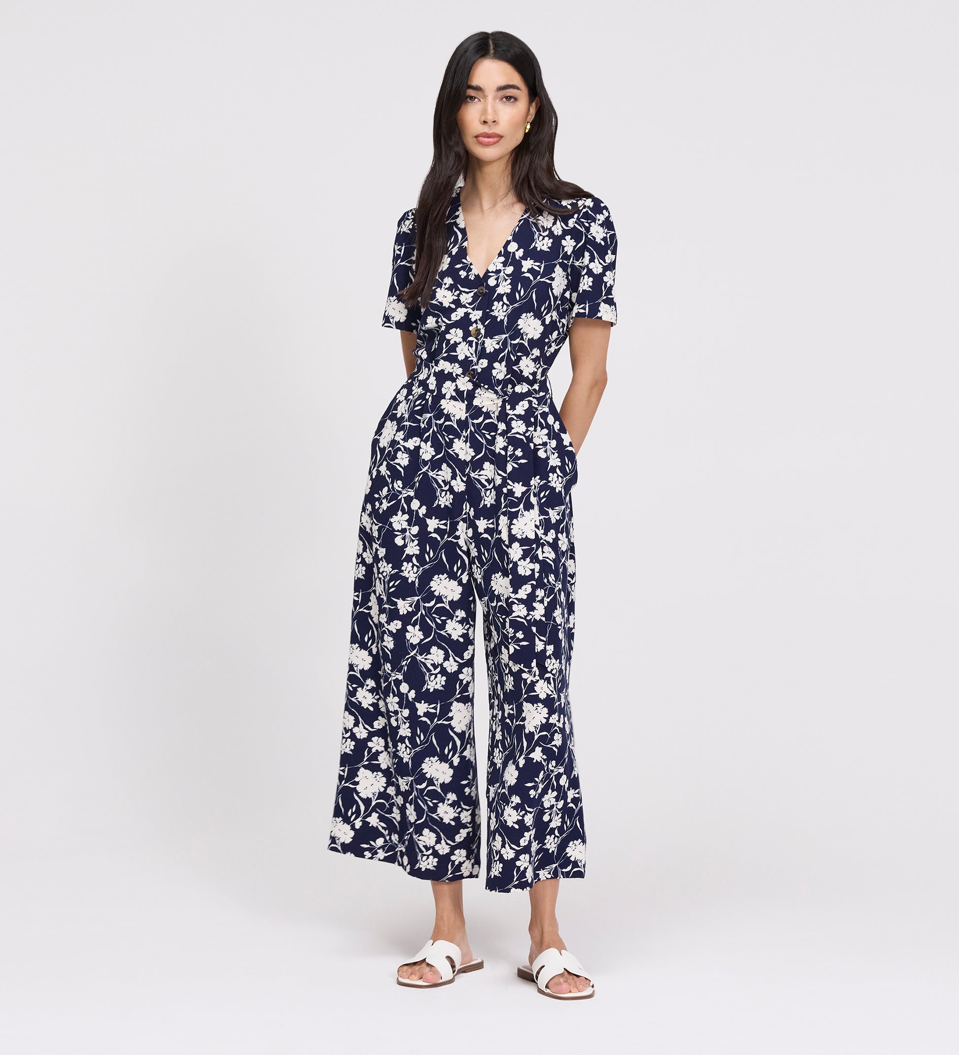 Woman wearing Uma Navy Floral Belted Wide Leg Jumpsuit on a white background