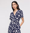 Woman wearing Uma Navy Floral Belted Wide Leg Jumpsuit on a light gray background