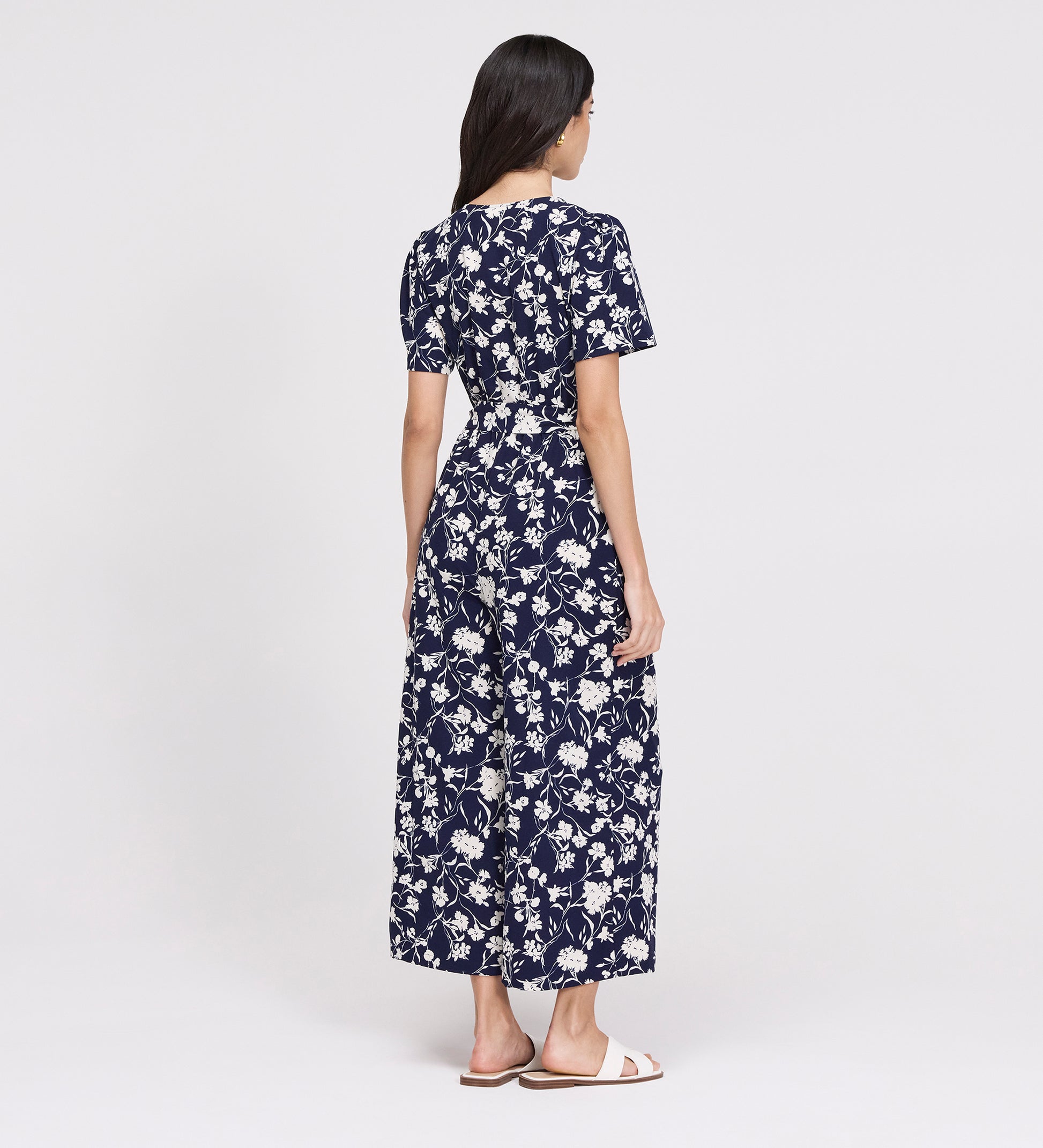 Woman wearing Uma Navy Floral Belted Wide Leg Jumpsuit on a white background
