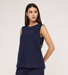 A woman with long dark hair wears the Vallie Navy Round Neck Vest and matching relaxed-fit pants, standing against a plain light background and looking to her left with a neutral expression.